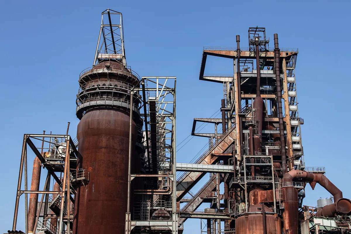 Conjunto de tubulações e vasos de processo em planta industrial, com flanges, válvulas e instrumentação