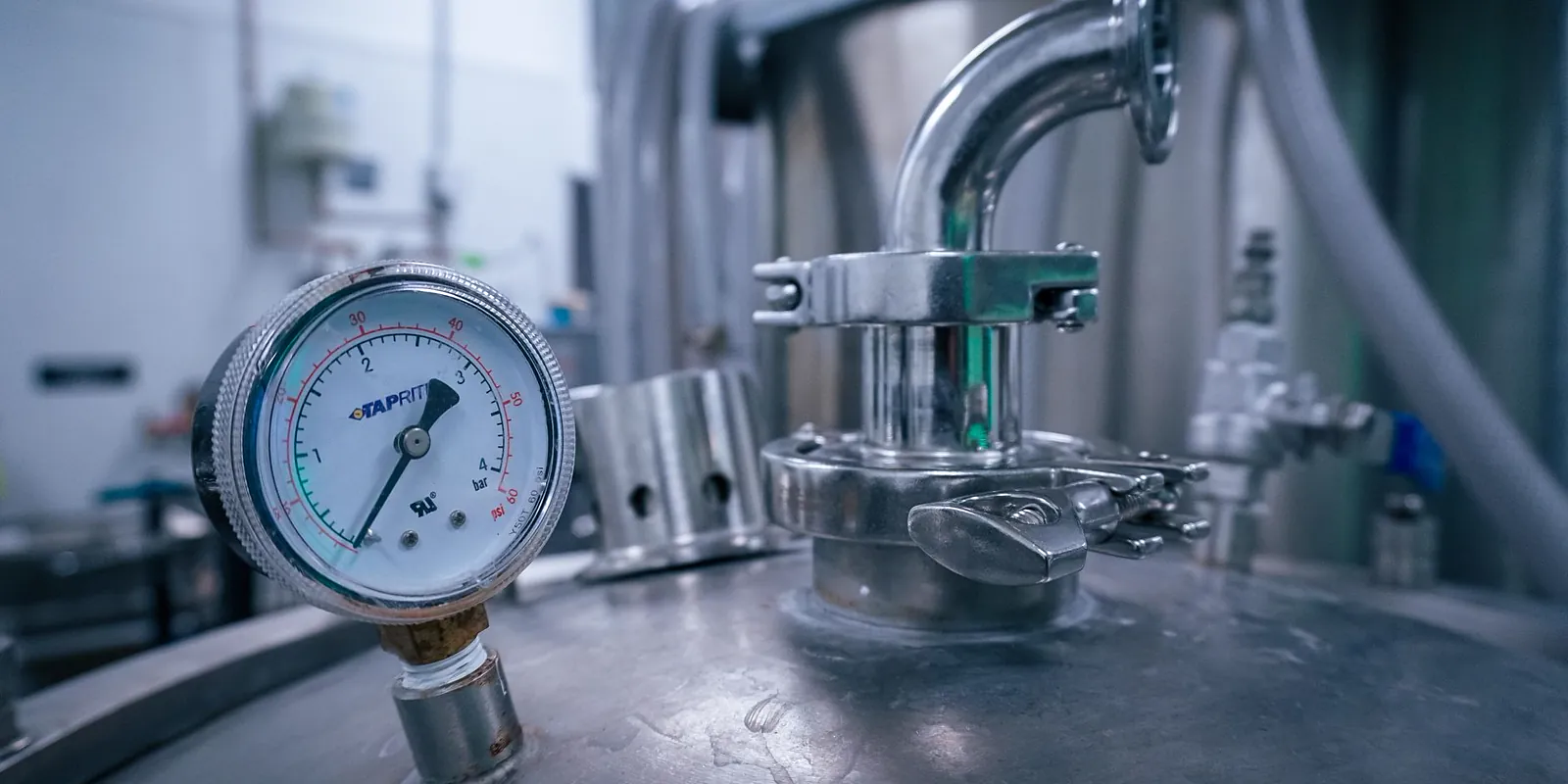 Manômetro instalado em vaso de pressão de aço inoxidável com válvulas e tubulação de processo