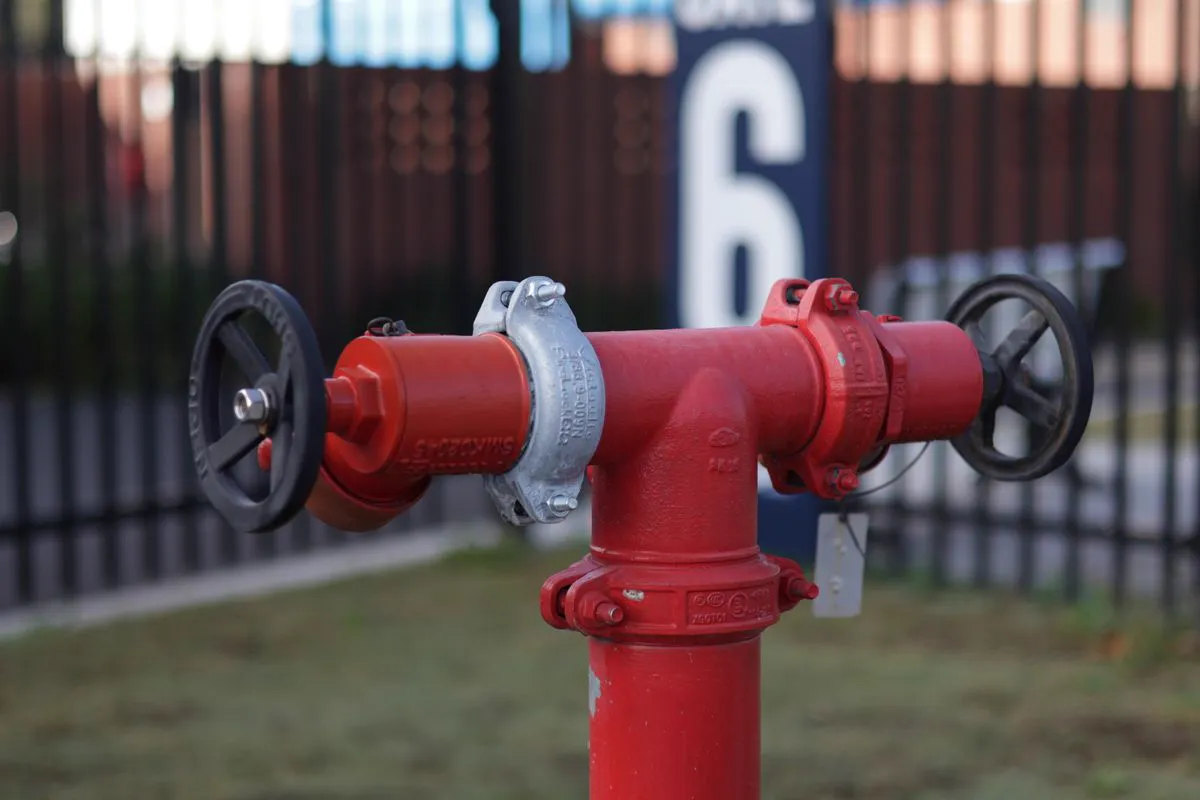 Hidrante de recalque vermelho com registro e conexão de engate rápido instalado em área externa