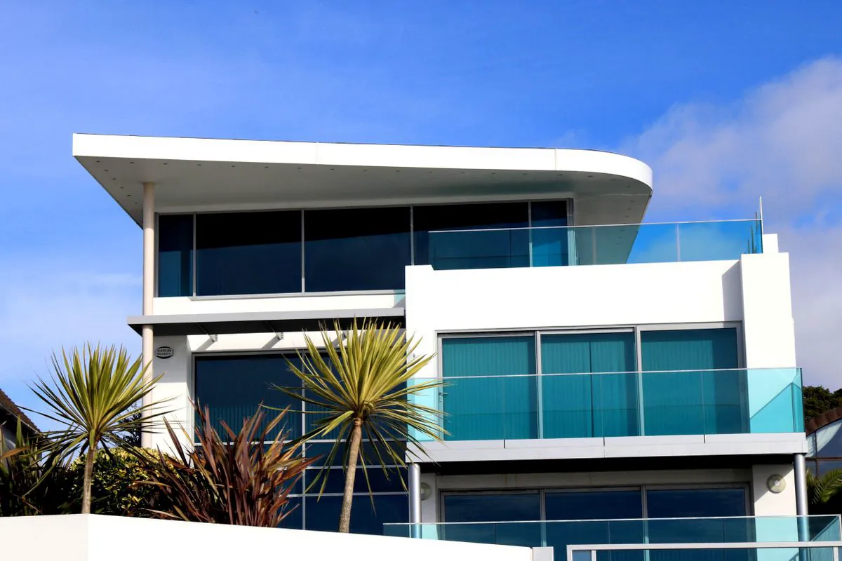 Casa moderna de três pavimentos com balanços, lajes finas e grandes panos de vidro