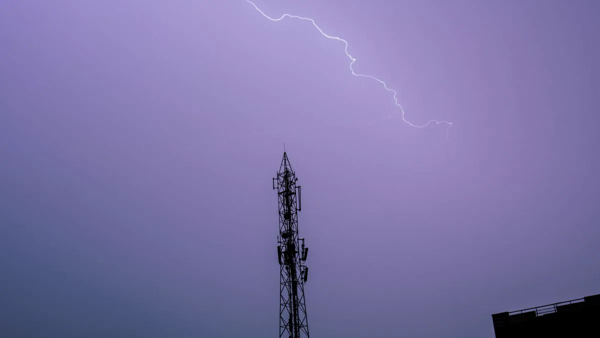 Descarga atmosférica atingindo a região de uma torre metálica com captor, ilustrando a atuação de um sistema de proteção contra descargas atmosféricas